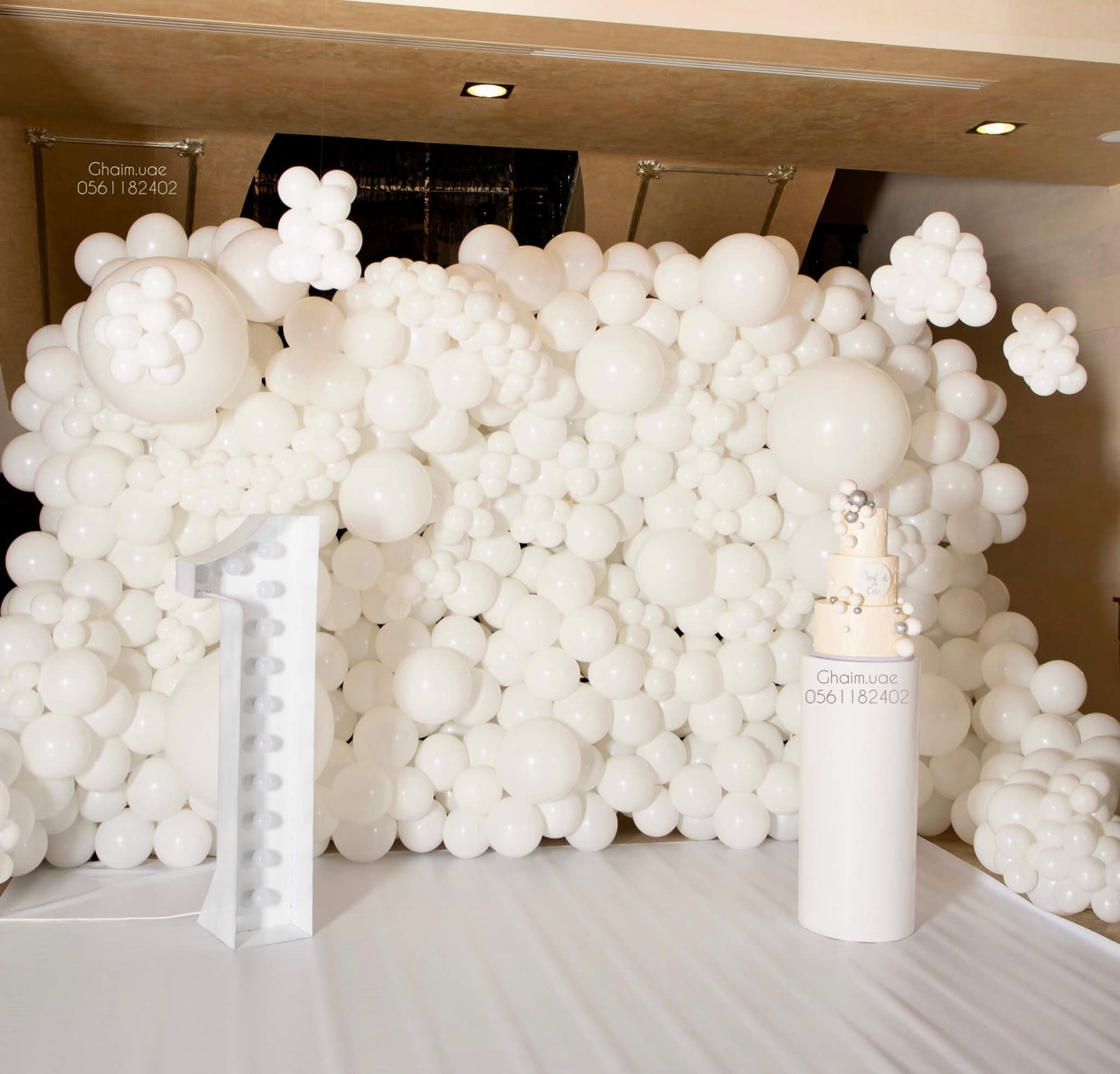All-white luxury balloon backdrop with number 1 decor for premium birthday in Dubai.