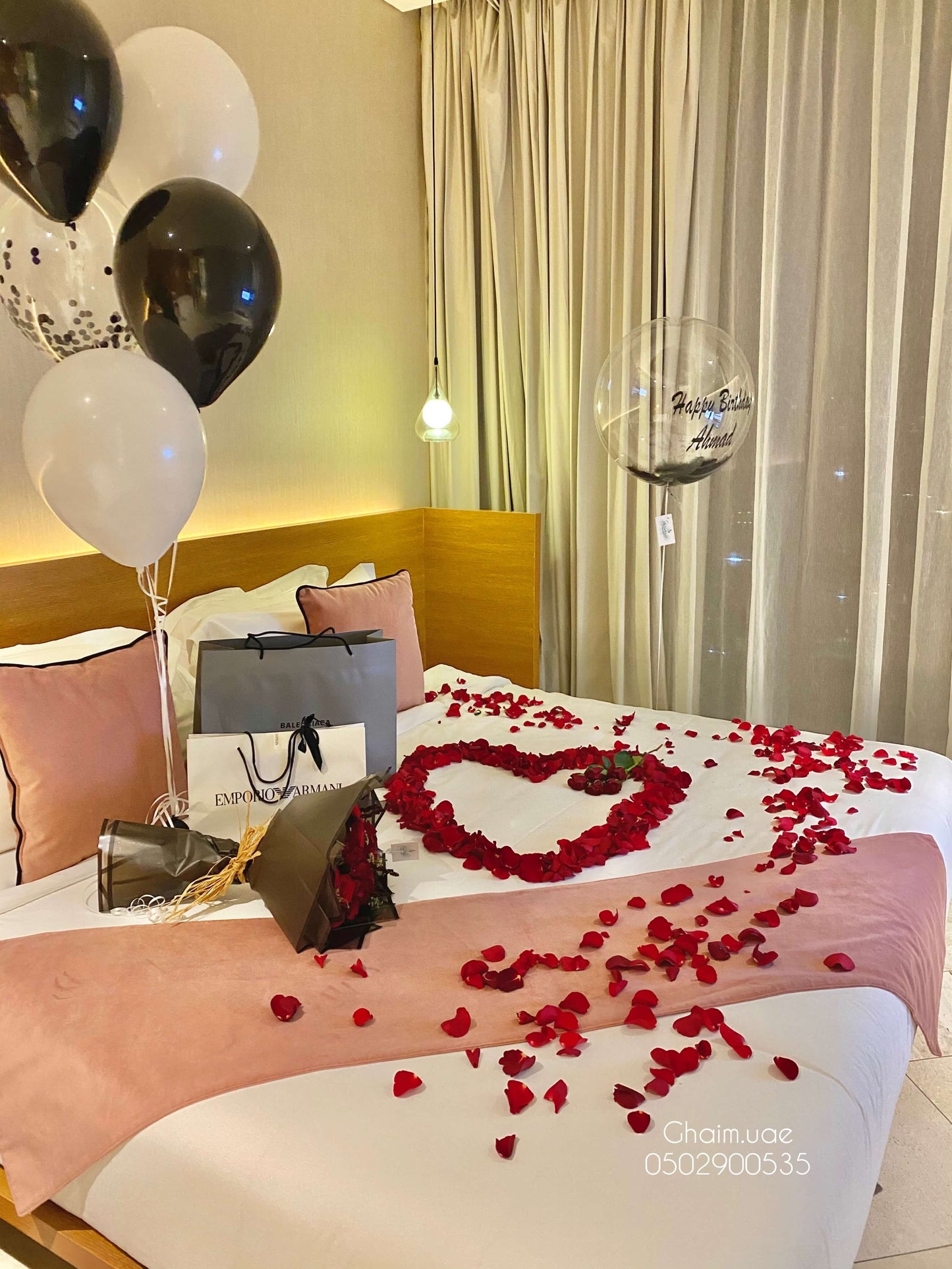 Luxury black and white balloon setup with rose petals on bed for birthday surprise Dubai UAE