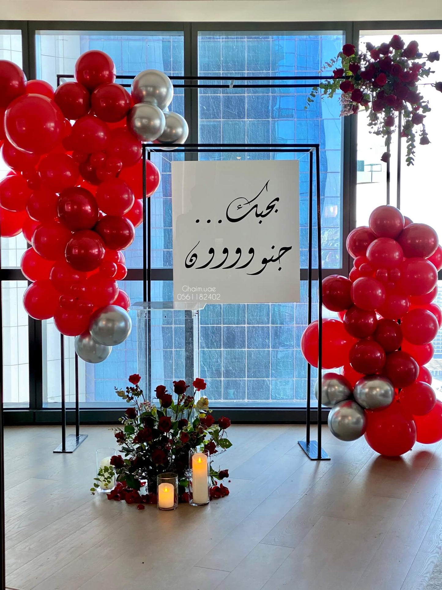 Red and silver balloon backdrop with roses and candles Dubai UAE