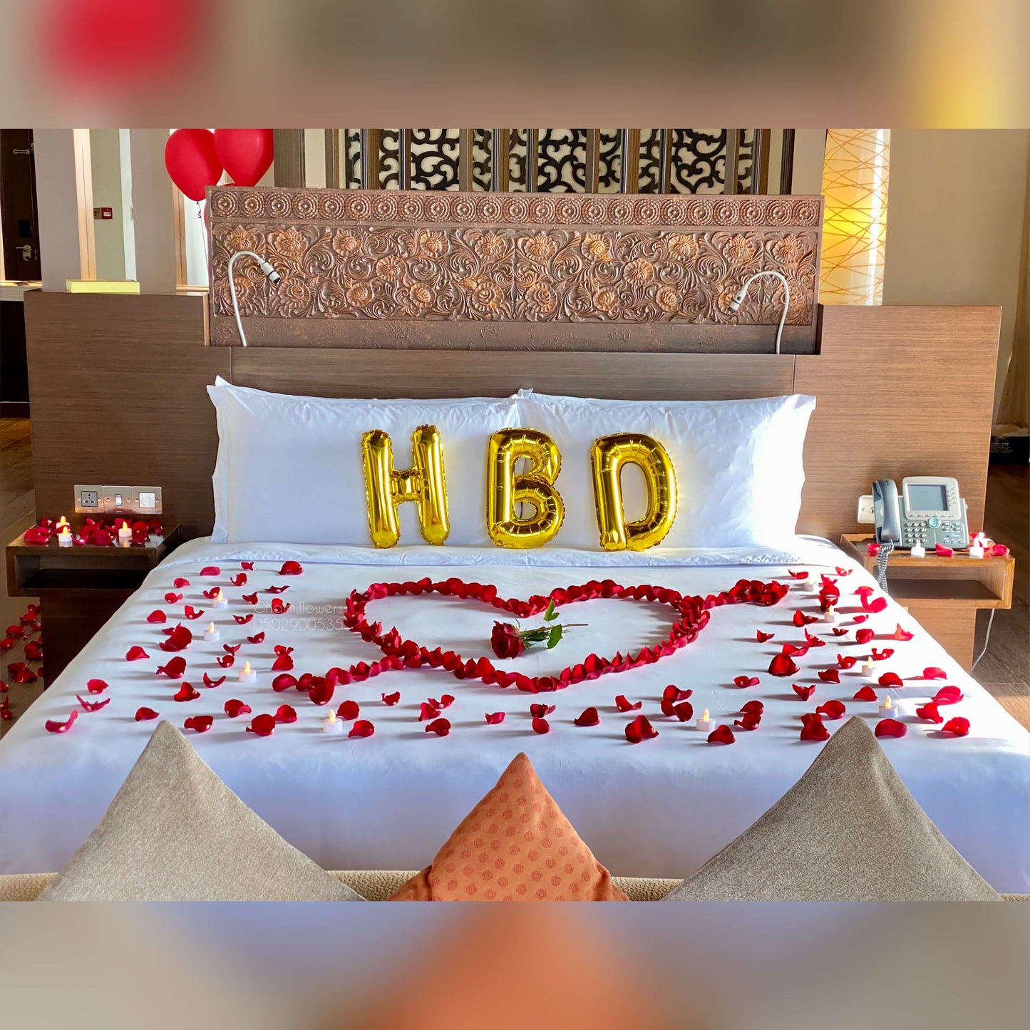 Luxury birthday bed decor with golden balloons and rose petals Dubai UAE