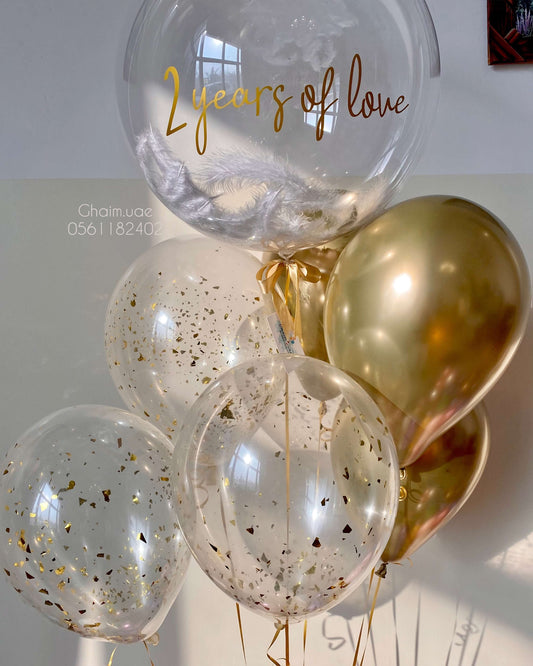 Gold helium balloon bouquet with confetti balloons and custom text bubble balloon