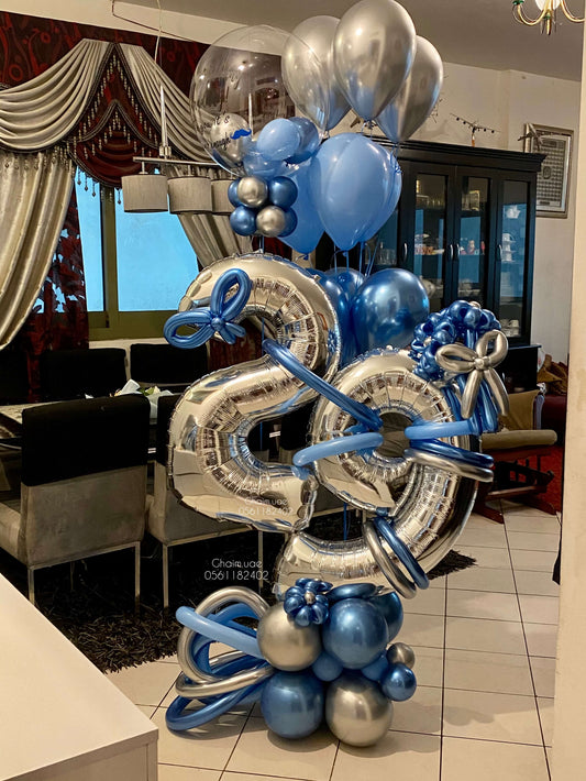 Silver and blue number balloon arrangement with helium balloons and custom text bubble balloon