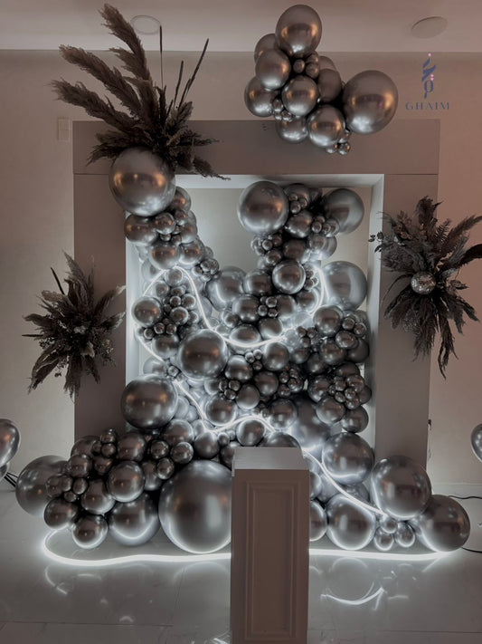 Luxury silver balloon arrangement with cascading metallic balloons, integrated LED lighting, pampas accents, and a white pedestal