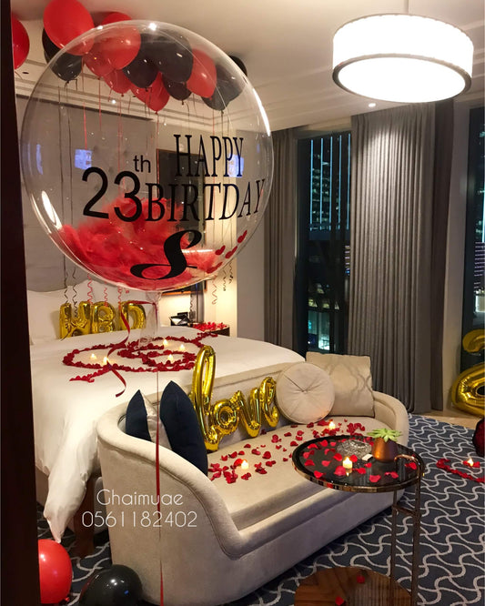 romantic birthday room decor with black and red balloons, gold numbers, and rose petals Dubai UAE