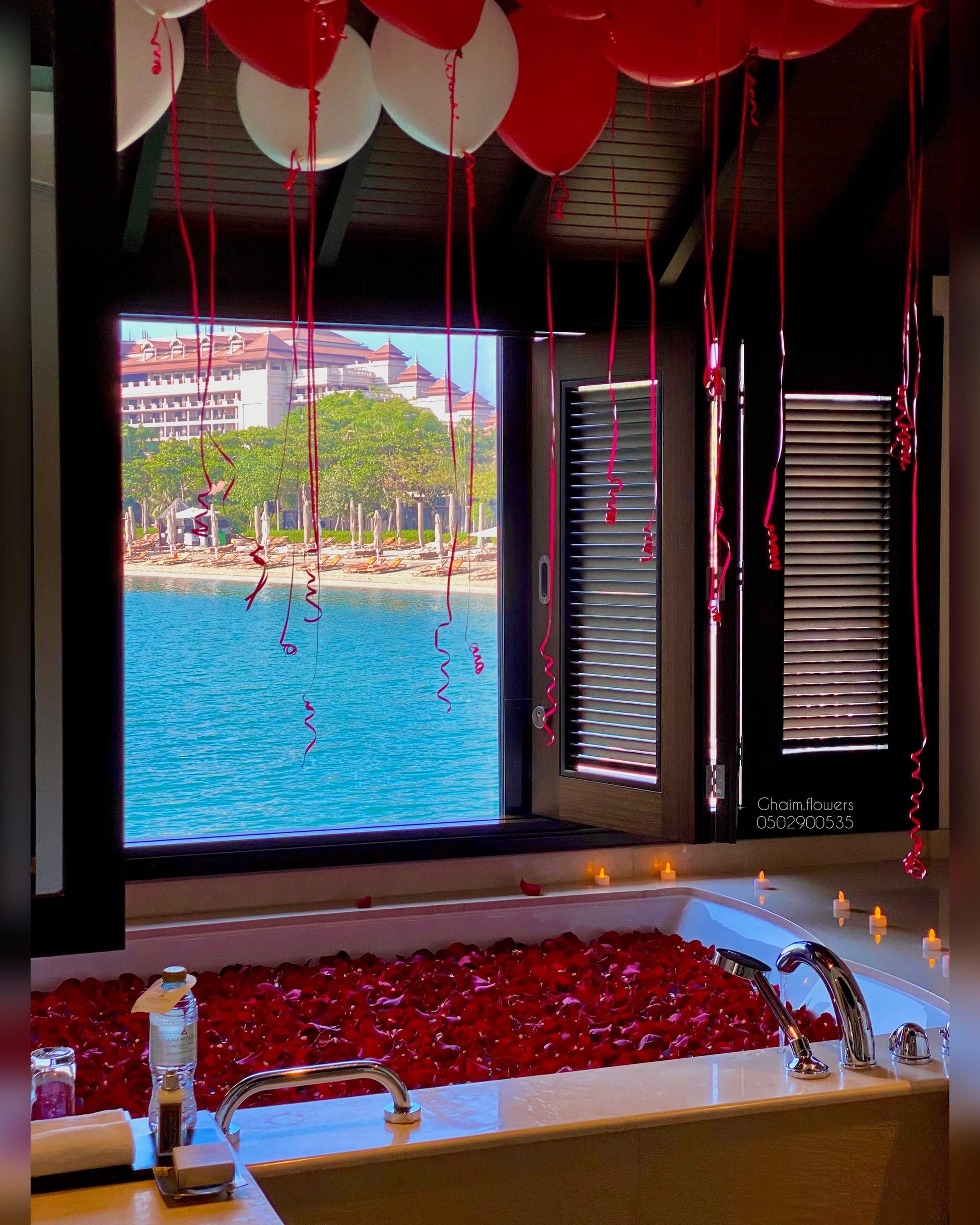 VIP romantic birthday setup with red and gold balloons, rose petals, luxury bathtub decor Dubai UAE